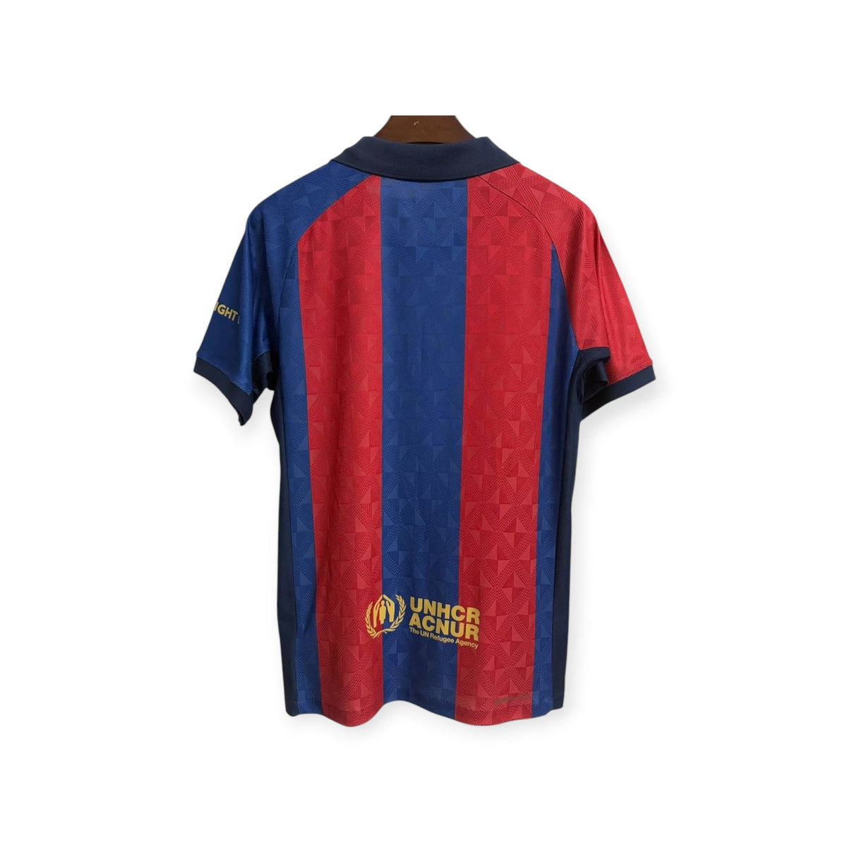Vista trasera de la camiseta retro FC Barcelona 2026/2027 de Archive Football con rayas rojas y azules y logo ACNUR