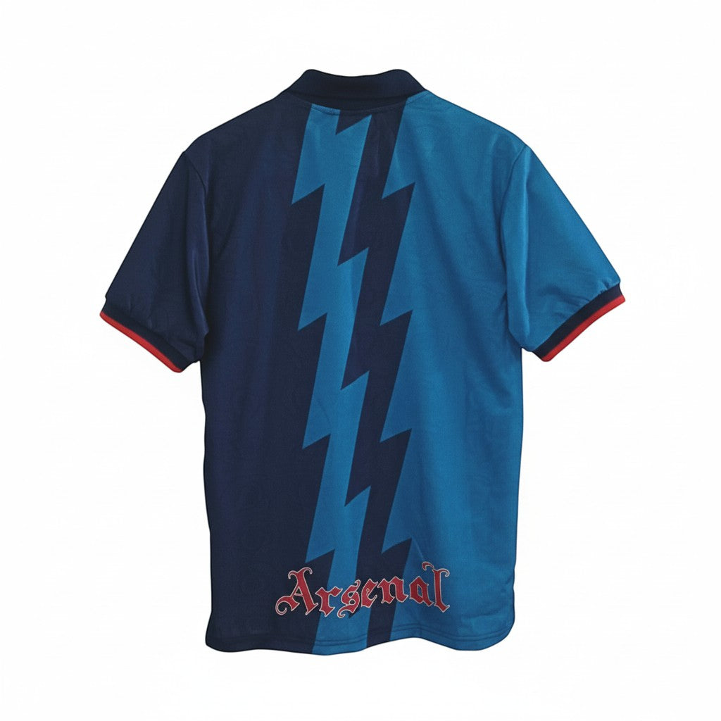 Hinchas Sportswear Store retro Arsenal 1994-95 away jersey. Navy blue with teal lightning bolt pattern and red trim.