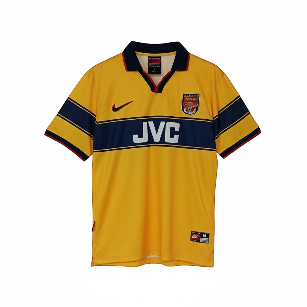 Hinchas Sportswear Store Arsenal 1997-99 retro away jersey. Yellow with navy chest band, JVC sponsor, red Nike swoosh, and Arsenal crest.