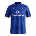 Hinchas Sportswear Store Chelsea FC retro 1989/91 home jersey by Umbro with Commodore sponsor. Royal blue with white collar and sleeve trim.