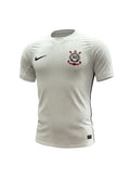 Camiseta de local Corinthians 2026/27 Nike blanca con textura jacquard de rayas verticales, ribetes negros y el escudo del club. Hinchas Sportswear Store.