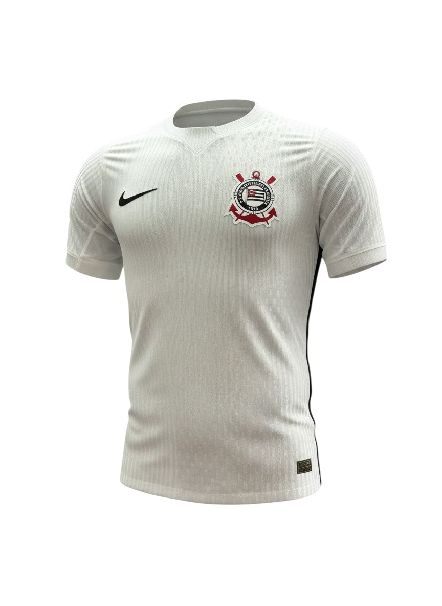 Camiseta de local Corinthians 2026/27 Nike blanca con textura jacquard de rayas verticales, ribetes negros y el escudo del club. Hinchas Sportswear Store.