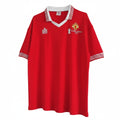 Hinchas Sportswear Store Manchester United 1977 FA Cup retro jersey in red with white V-neck collar and striped cuffs. Features commemorative Silver Jubilee badge.