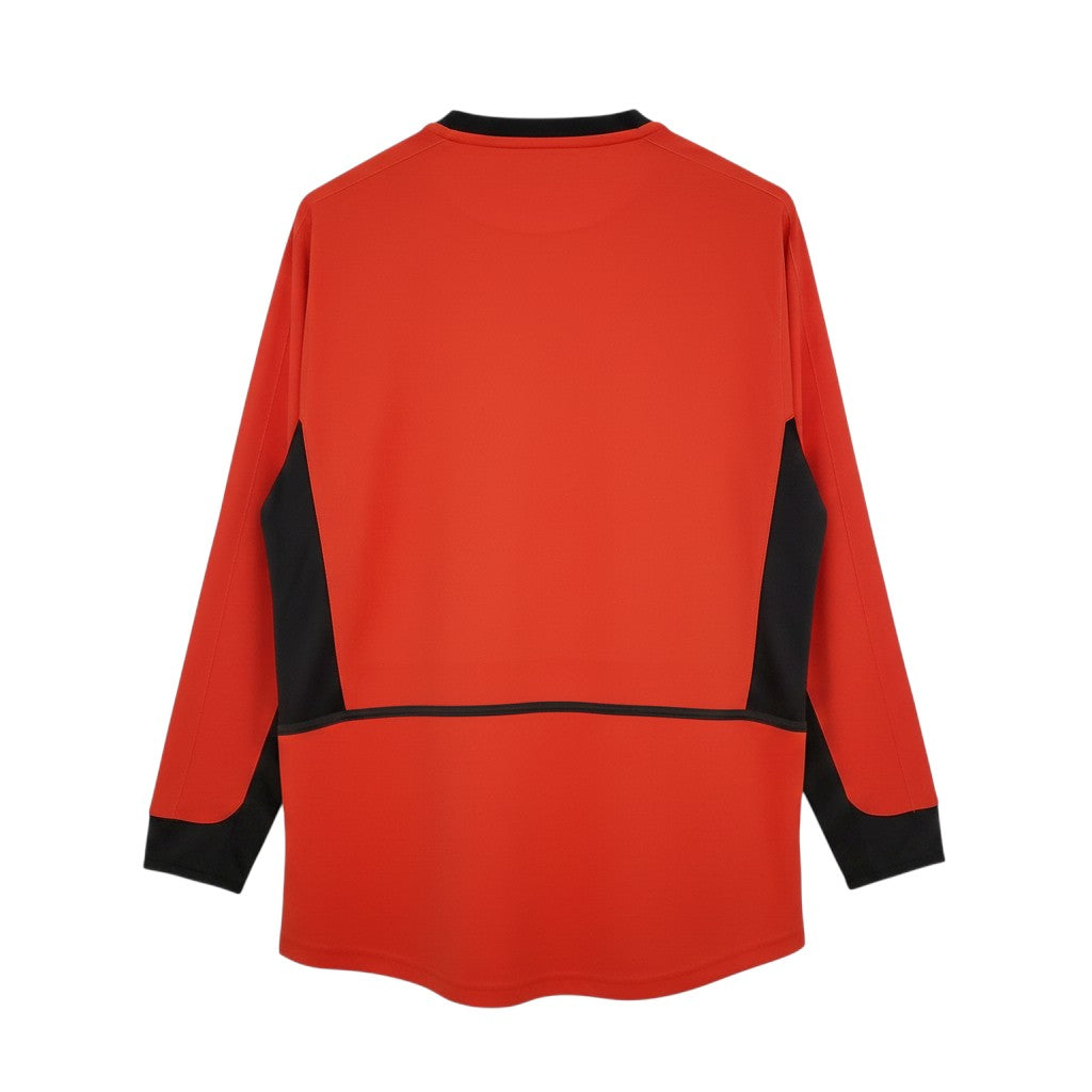 Hinchas Sportswear Store Manchester United 2002-03 red long sleeve retro jersey with black side panels and collar trim.