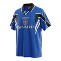 Hinchas Sportswear Store Manchester United 1996-97 retro third jersey in royal blue, black, and white. Features Umbro branding, Sharp sponsor, and chevron details.
