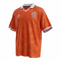 Hinchas Sportswear Store Netherlands 1991 retro home jersey. Orange with geometric pattern, white polo collar with red, white, blue trim, and KNVB crest.