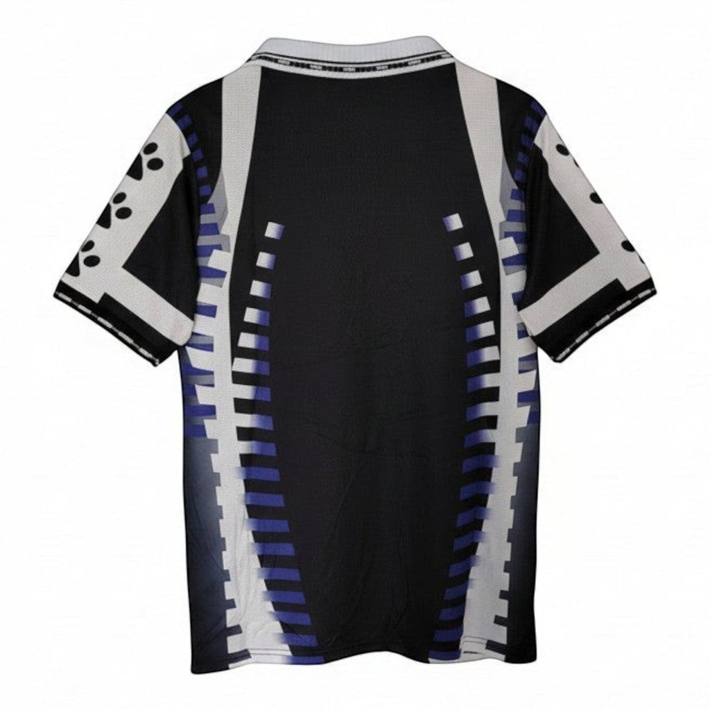 Hinchas Sportswear Store Real Madrid 1996-97 retro away jersey. Black with white and purple geometric patterns, short sleeves, polo collar.